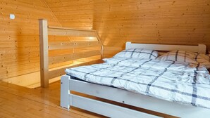 A wooden cabin bedroom with a bunk bed, a slanted ceiling, and a wooden floor. - 2 bedroom cozy home in Kladno (Kladno)