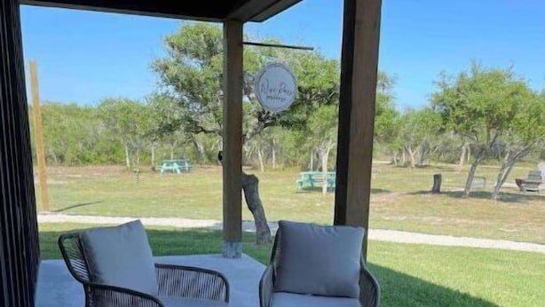 A covered patio with wicker furniture and a sign reading "Wickham's."
