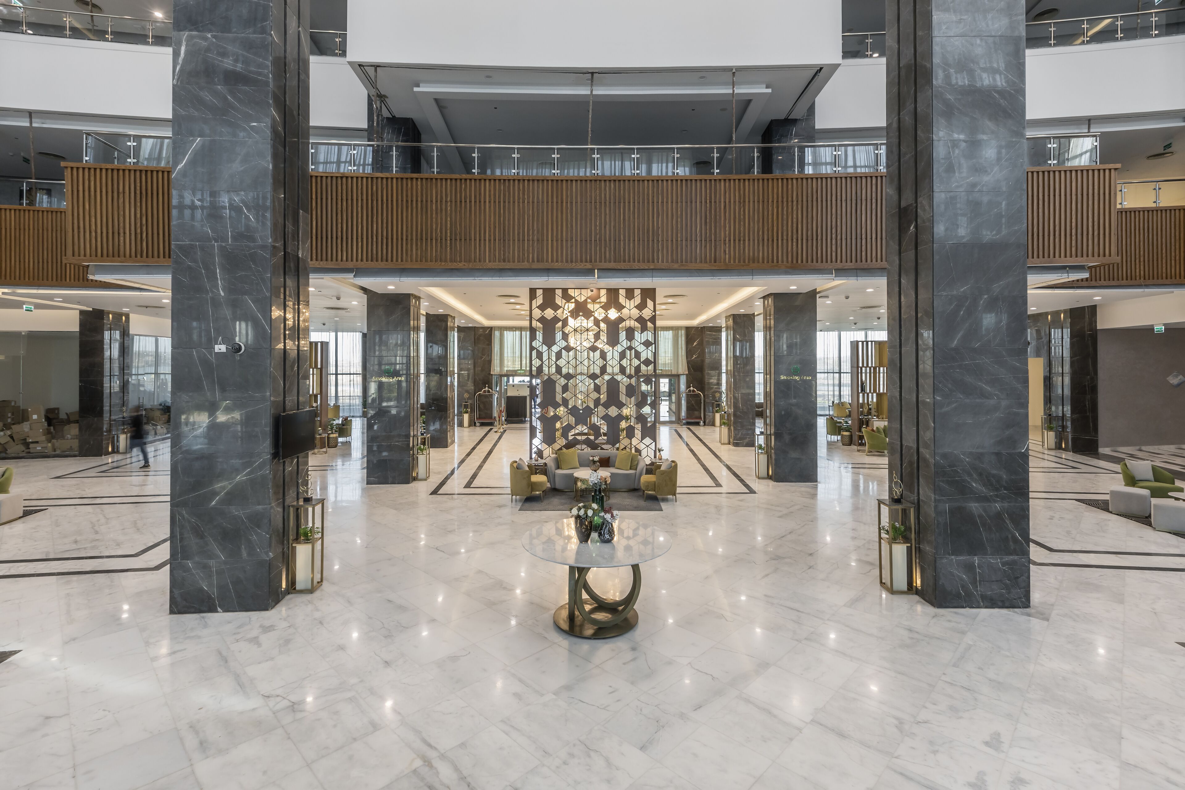 A spacious lobby with a central round table, high ceilings, and a modern design.
