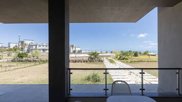 Enjoy a serene view from this outdoor space with a table and chairs under a shelter.