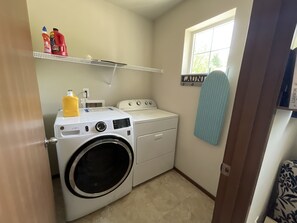 Laundry room with a front-loading washer and dryer, plus a convenient shelf for storage.