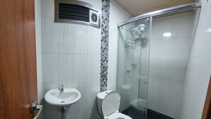 A bathroom with a sink, toilet, and shower.