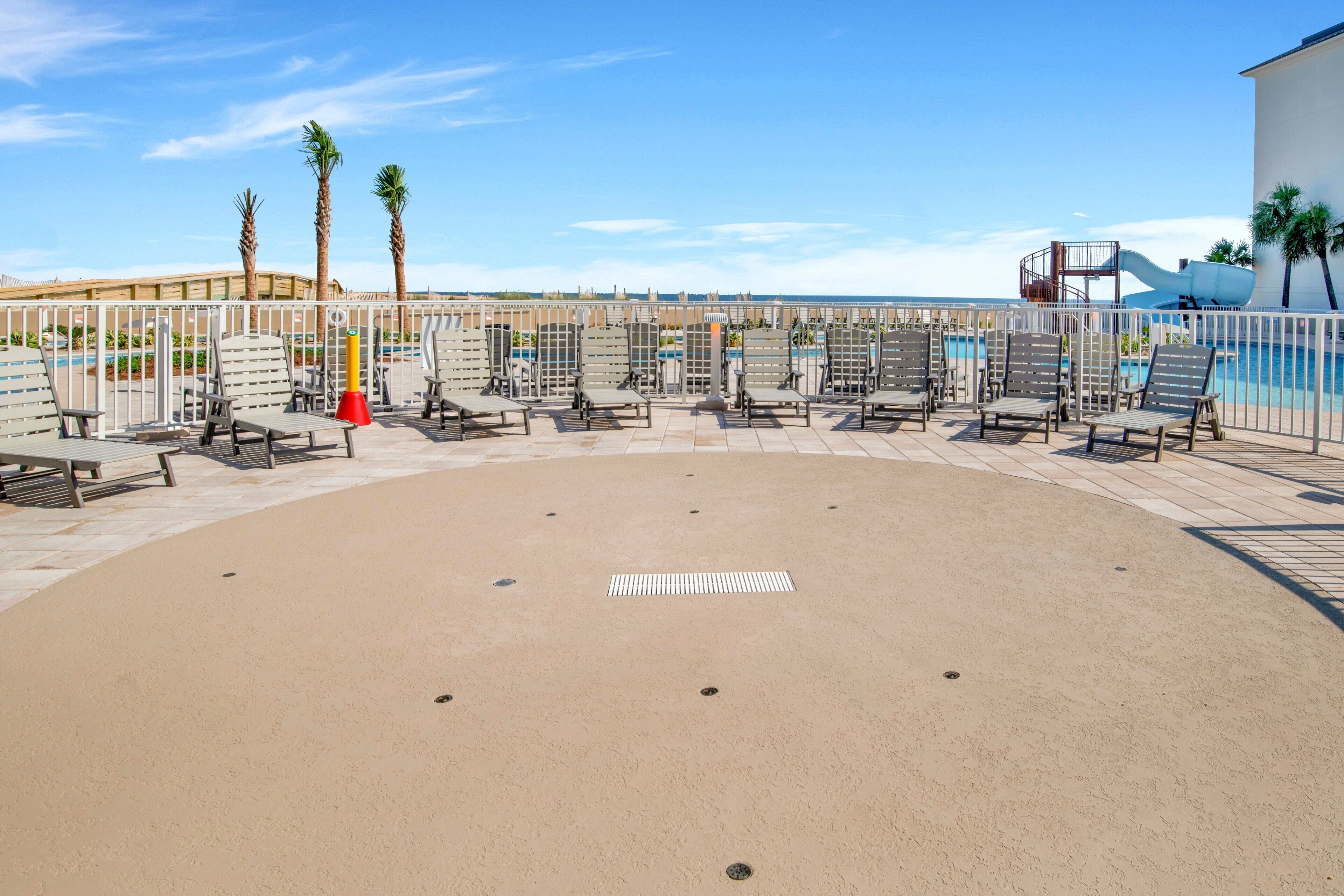 A poolside area with lounge chairs and a water slide.