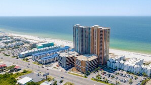 Un grand hôtel à plusieurs étages, doté d’un parking et offrant une vue sur la plage.