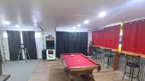A room with a pool table, chairs, and a projector. - Hillbilly Haven (Equinunk)
