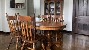A dining room with a wooden table and chairs, a cabinet with glass doors, and a door. - The Seabreeze  (Dayton)