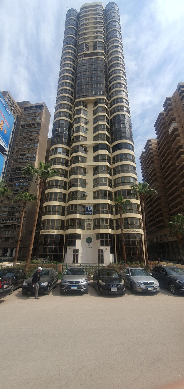 Um edifício de hotel alto e curvo, com várias varandas e uma entrada central.