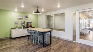 Una cocina moderna con una mesa de madera, sillas y un armario blanco.
