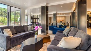 Un salón moderno con sofá, mesa de centro y vistas al exterior.