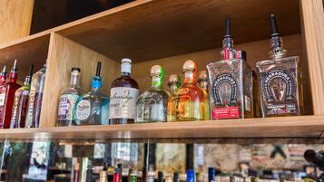 Diverse drankflessen op planken in een bar.