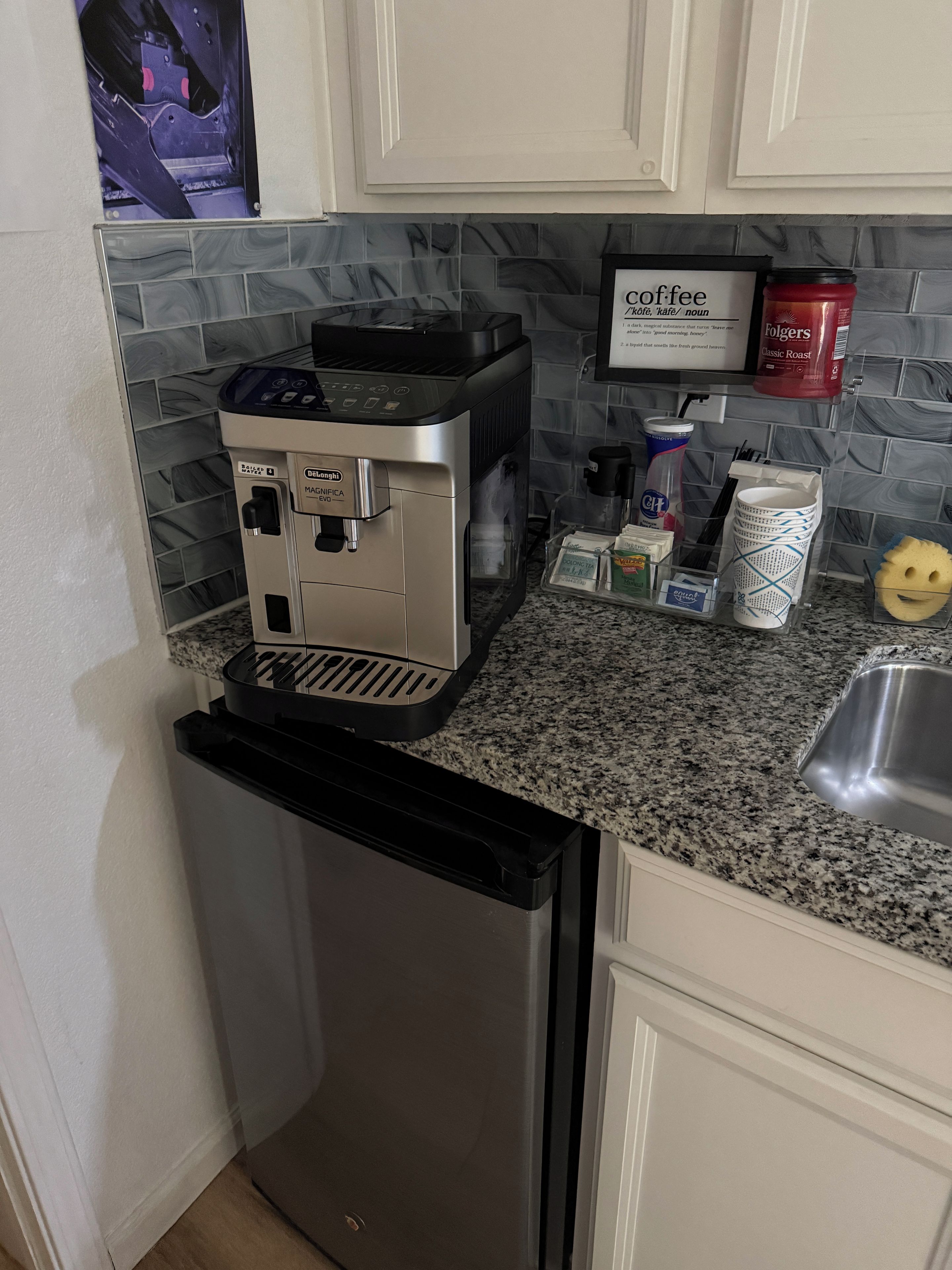 A coffee machine, a refrigerator, and a coffee maker on a kitchen counter.
