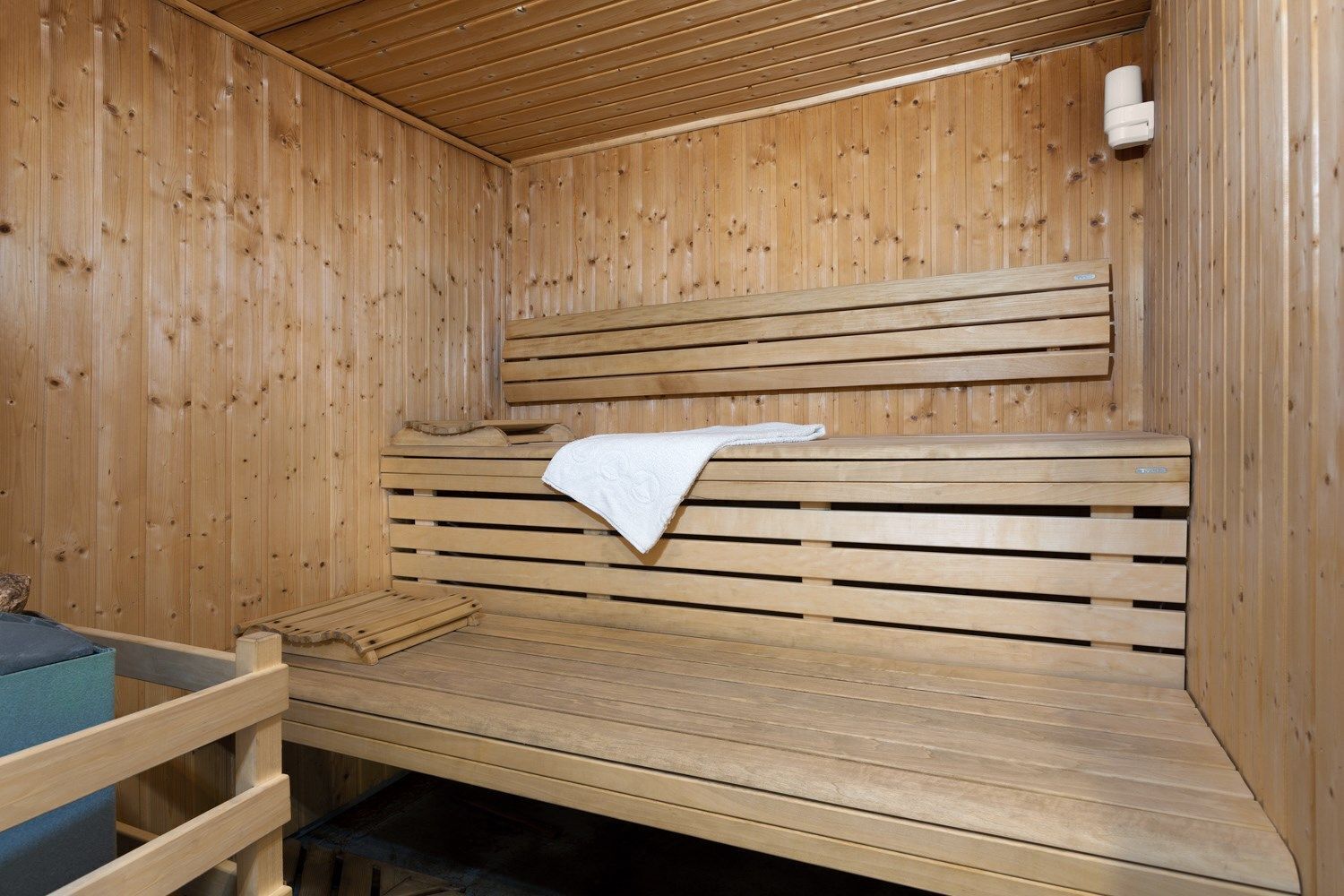 Een houten sauna met banken en een zitbank.