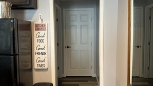 A hallway with a sign reading "COLUMBIA Mississippi" and a sign listing "KITCHEN RULES" on the wall.