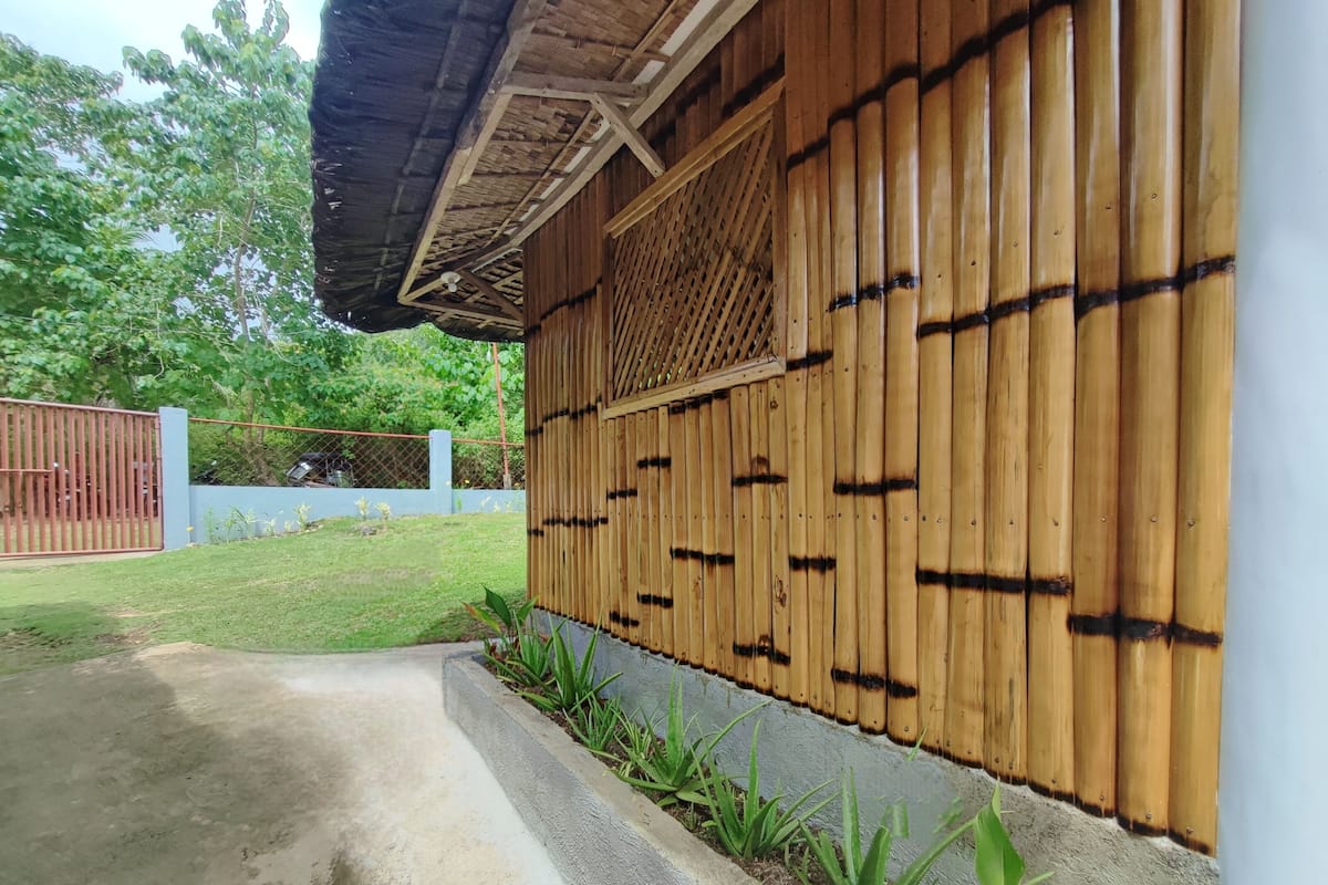 A wooden exterior wall with vertical planks and a lattice window.