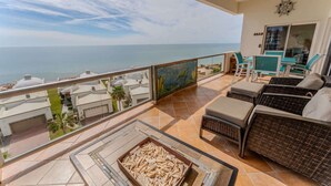 A balcony with a view of the sea, wicker furniture, and a tiled floor. - Grande 504, Las Palmas Resort (Puerto Peñasco)