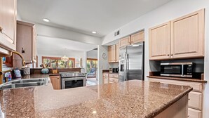 A modern kitchen with granite countertops, stainless steel appliances, and wooden cabinets. - Pet Friendly ~ Marsh Views ~ Private Pool w/ Free Pool Heat ~ 25 Stoney Creek Rd (Hilton Head Island)