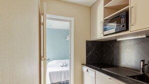 A compact kitchen with a microwave, a dishwasher, and a small sink.