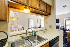 Kitchen area with a stainless steel sink, dishwasher, and wooden cabinets.