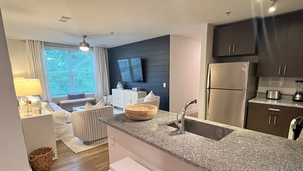 Eine moderne Küche mit Granit-Arbeitsplatten, Edelstahlgeräten und einem eingebauten Backofen.