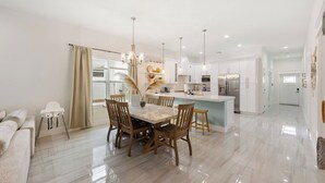A modern kitchen with white cabinets, a central island, and pendant lighting. - New*Mini-Golf*Heat or Chill Saltwater Pool*Arcade (Jensen Beach)