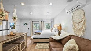 A modern bedroom with a bed, bedside table, lamp, and a decorative wall hanging. - 20% Off Valentines Studio at Sundance Utah (Sundance)