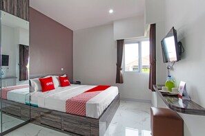 A modern hotel room with a large bed, a TV mounted on the wall, and a desk with a chair. - Oyo 91665 D'prof Exclusive Guesthouse (Semarang)