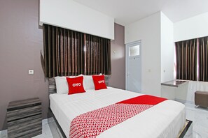 A hotel room with a large bed, two red pillows, a white bedspread, and a red and white patterned throw. - Oyo 91665 D'prof Exclusive Guesthouse (Semarang)