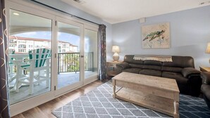 Ein Wohnzimmer mit einer Couch, einem Couchtisch und einem Balkon mit Stühlen.