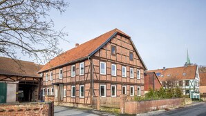 A traditional half-timbered building with a steeply pitched roof, multiple windows, and a brick wall. - Holiday Apartment "Bartölke" with Wi-Fi (Bockenem)