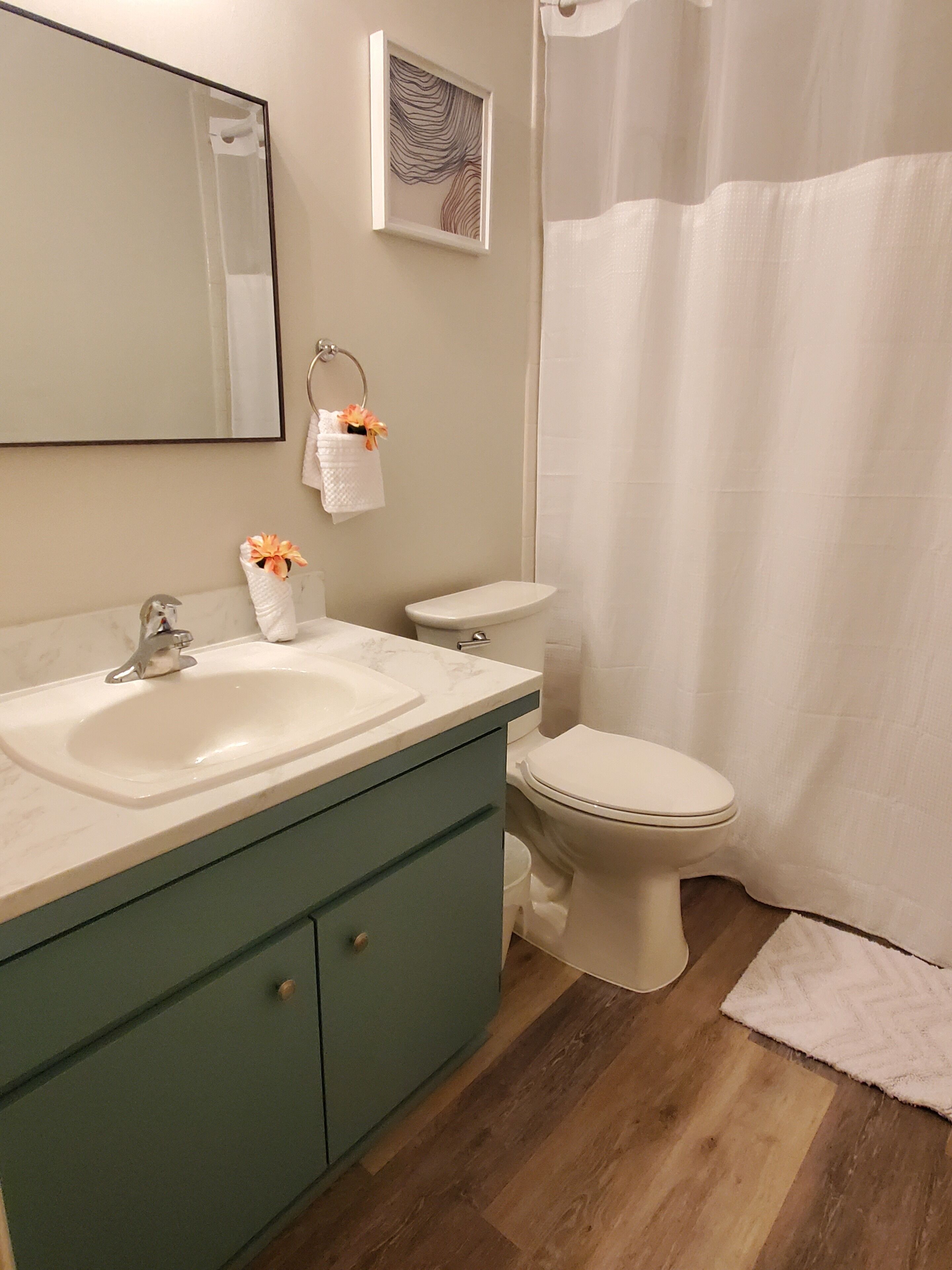A bathroom with a sink, toilet, and shower curtain.