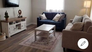 A living room with a TV, two sofas, a coffee table, and a TV stand. - Welcome to Casa de Cruz where everything is a short drive away! Perfect for you! (Tampa)