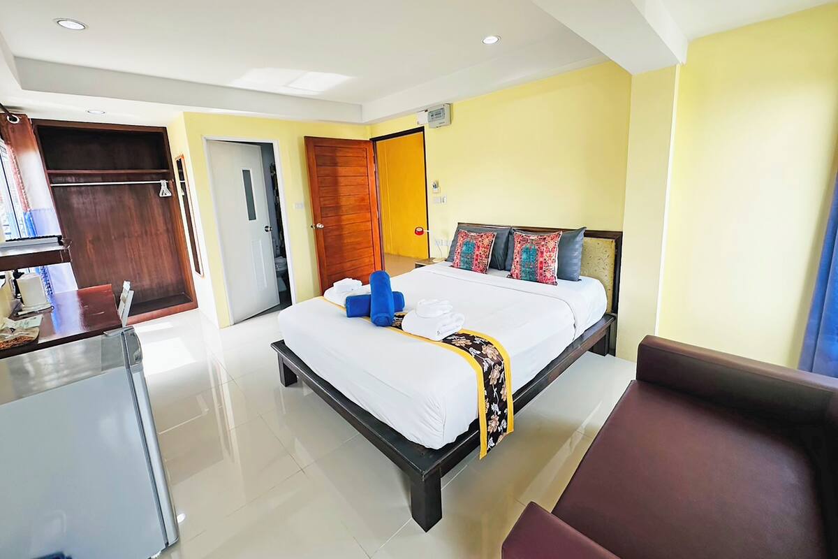 Una habitación de hotel con cama, escritorio, silla y armario.