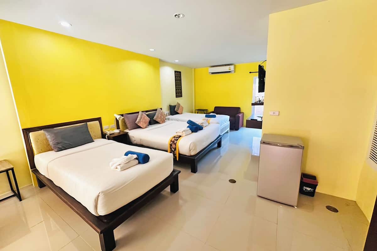 Habitación de hotel con dos camas, una kitchenette pequeña y un baño compacto.