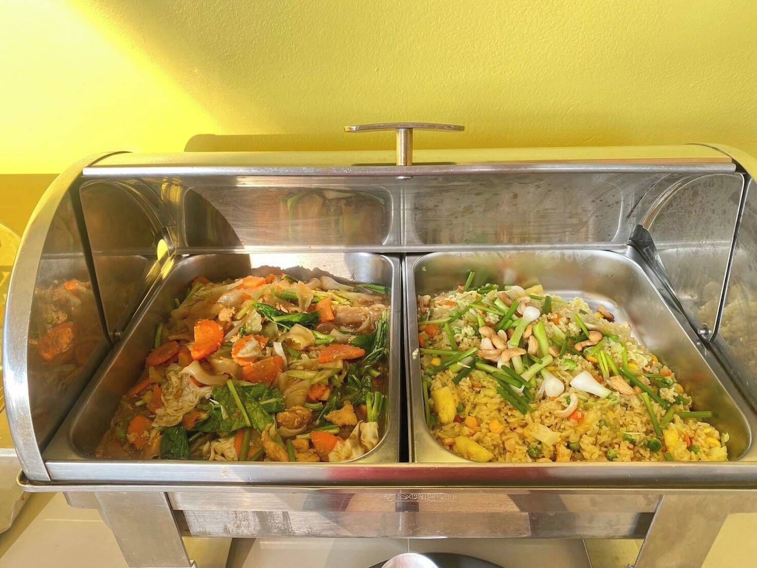 A buffet with two sections of food, including vegetables and rice dishes.