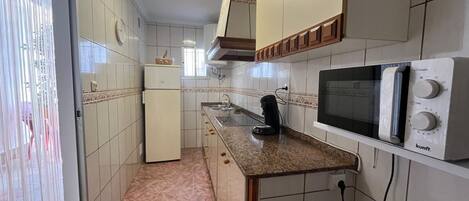 Refrigerador, microondas, cafetera y tetera y utensilios de cocina