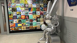 A modern hotel lobby with a large wall of colorful artwork and a silver rabbit sculpture. - ARTHOME HOTEL (Kaohsiung)