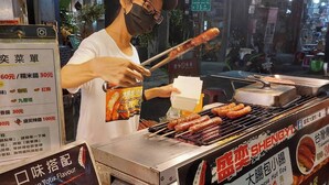 A street food vendor grilling sausages at night. - ARTHOME HOTEL (Kaohsiung)
