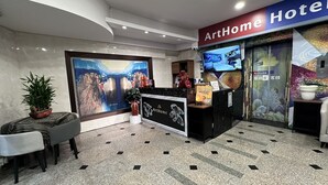 A hotel reception area with a modern design, featuring a reception desk, seating area, and a large painting on the wall. - ARTHOME HOTEL (Kaohsiung)