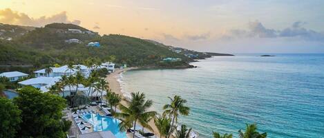 Un resort con piscina, playa y vistas al océano.