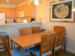 Enjoy meals at the dining table with six chairs, surrounded by a kitchen with appliances.