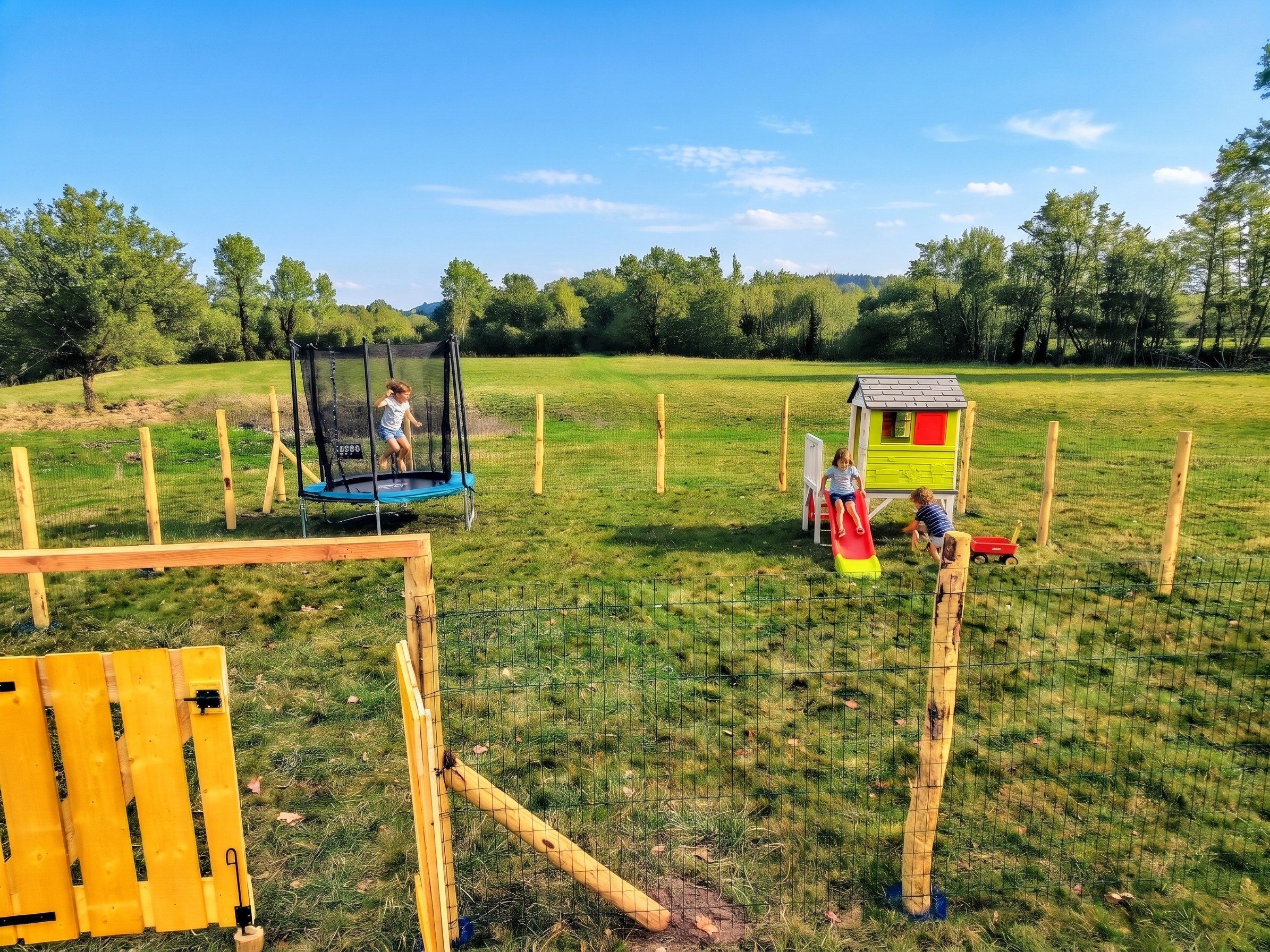 A fenced outdoor area with a trampoline, a playhouse, and a slide.