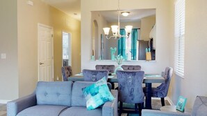 A dining area with a chandelier, a large mirror, and a blue and gray color scheme. - PERFECT, NEW! 6 Min to Dis, On Lake, Brand Name Beds, Big  T.Vs, Steps to Pool.  (Kissimmee)