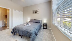 A bedroom with a bed, bedside lamps, a door, and a window with blinds. - PERFECT, NEW! 6 Min to Dis, On Lake, Brand Name Beds, Big  T.Vs, Steps to Pool.  (Kissimmee)