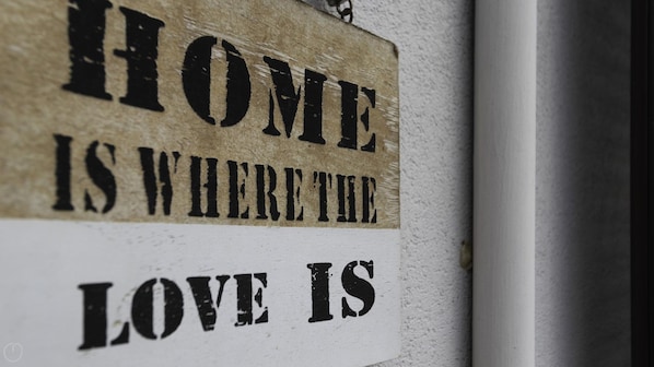 A sign with the text "HOME IS WHERE THE LOVE IS".