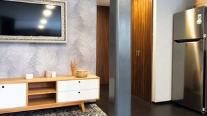 Une cuisine moderne avec un réfrigérateur en acier inoxydable, un meuble en bois et un crédence décorée.