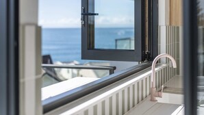 A balcony with a view of the sea, a modern faucet, and a glass door. - Namanula 7 - Oceanstays (Yamba)