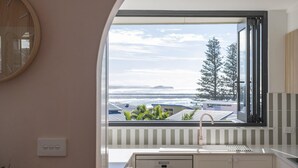 A kitchen with a large window, a sink, and a clock on the wall. - Namanula 7 - Oceanstays (Yamba)