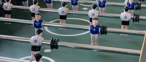 A foosball table with miniature figures in blue and white uniforms.