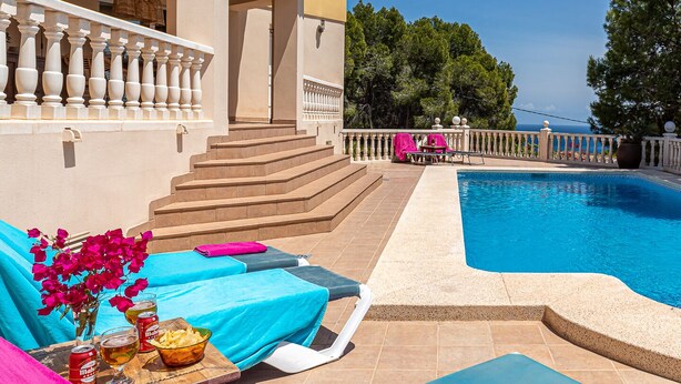 A pool area with a clear view of the sea, a set of stairs leading to a covered area, and a table with drinks and snacks. - Belle Vue - Altea, Costa Blanca (Altea)