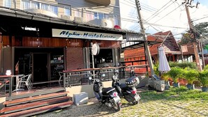 A hostel with a sign reading "Alpha Hostel Cafe & Bar". There are two motorcycles parked in front. - ALPHA Hostel Cafe&Bar (Krabi)